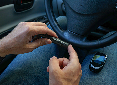 Man checking blood sugar in car