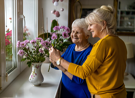 Two women tending to a vase of flowers