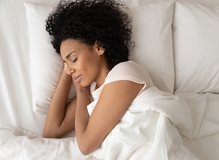 Woman sleeping peacefully in white bed