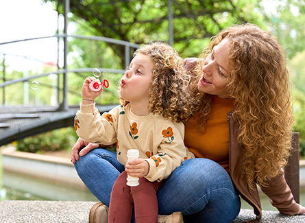 Mother with daughter blowing bubbles