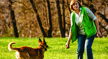 woman playing outside with her dog