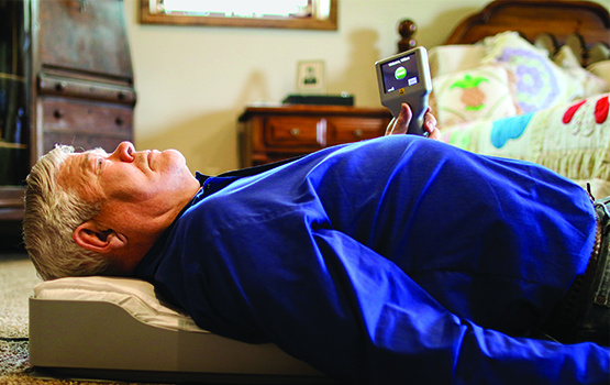 man laying on the floor on the CardioMEMs pillow