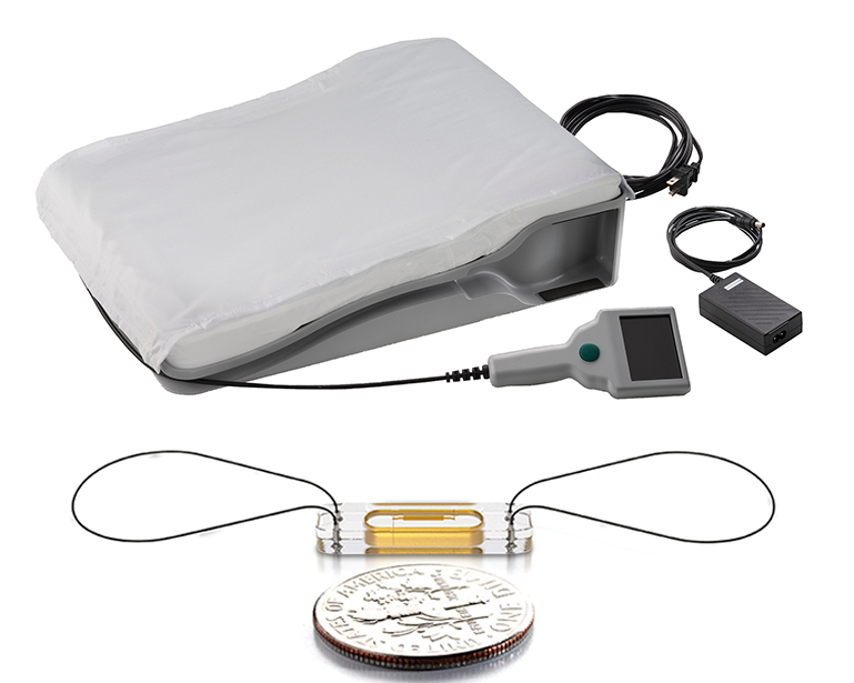 CardioMEMS is a 15 mm wide by 2 mm deep sealed monitoring sensor (bottom) and a special pillow (top) patients recline on each morning to wirelessly transmit readings to the Heart Care Clinic.