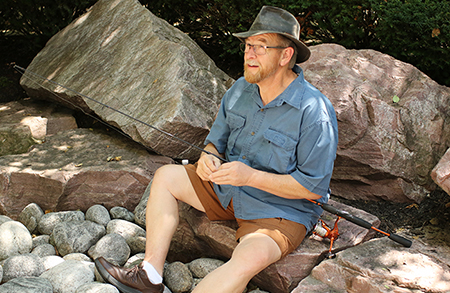 Man sitting on rocks fishing