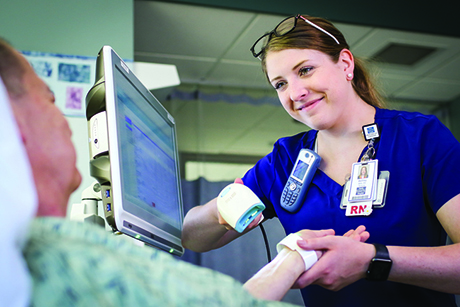 female nurse smiling with male patient in hospital bed