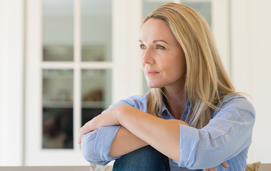 woman sitting with arms crossed over bent knee 