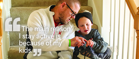 Brandon and his daughter sitting on stairs comparing their fitness trackers before heading outside for a walk.