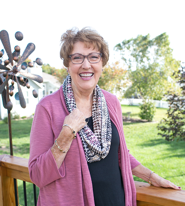 smiling woman standing on her deck