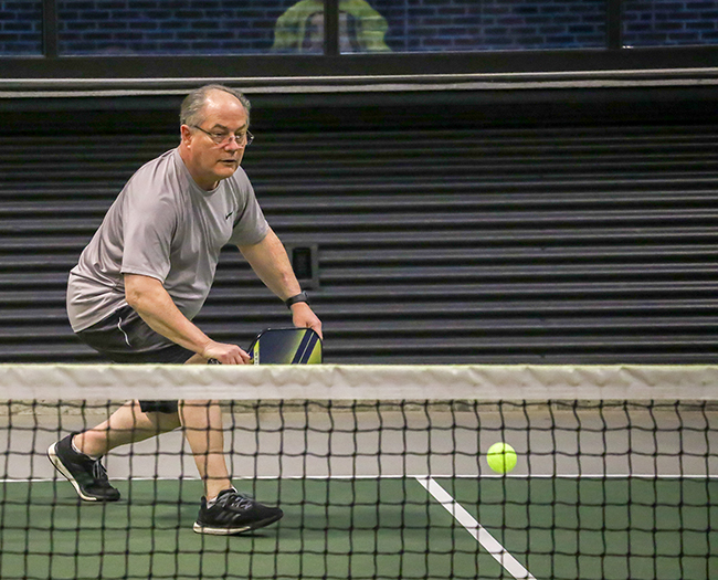 middle age man in t-shirt and short on a pickleball court