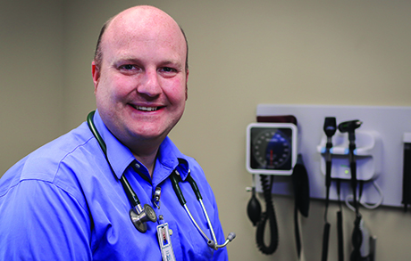 doctor with stethoscope around next in exam room